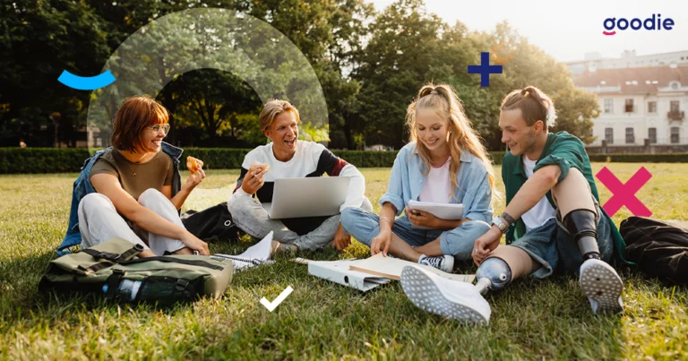 Nowy rok akademicki: grupa uśmiechających się studentów siedząca na trawniku z notesami przed kampusem uniwersyteckim.